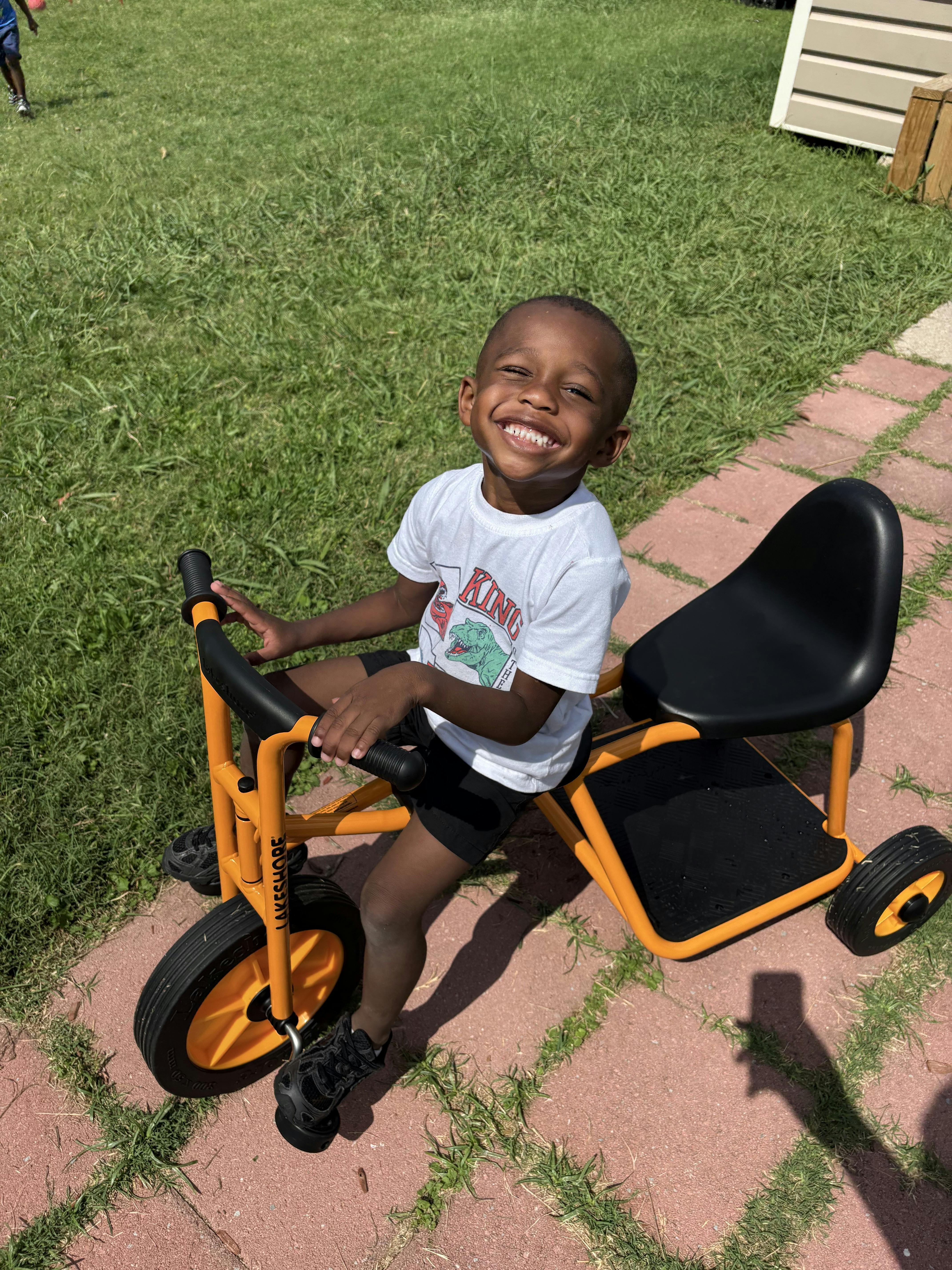 Child riding a tricycle on a paved path