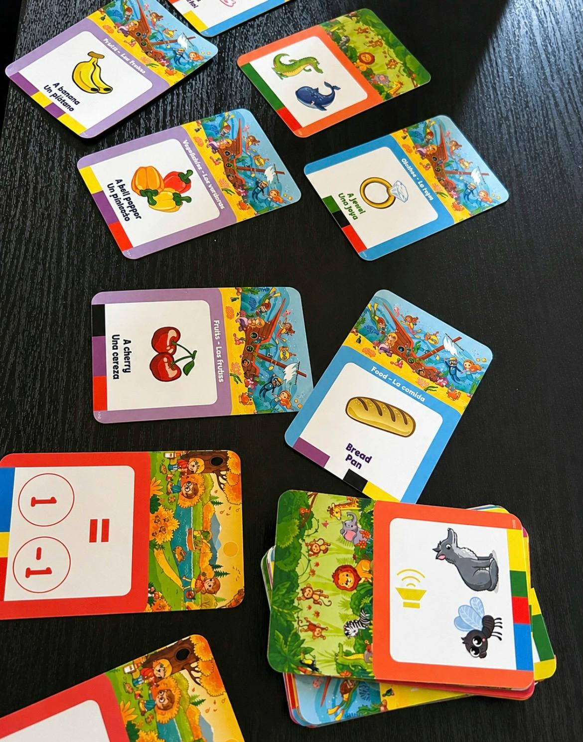 Educational flashcards with images and words scattered on a black table