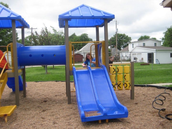 Child on a blue playground slide