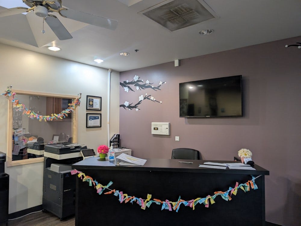 An office reception area with a black desk, television, and copy machine