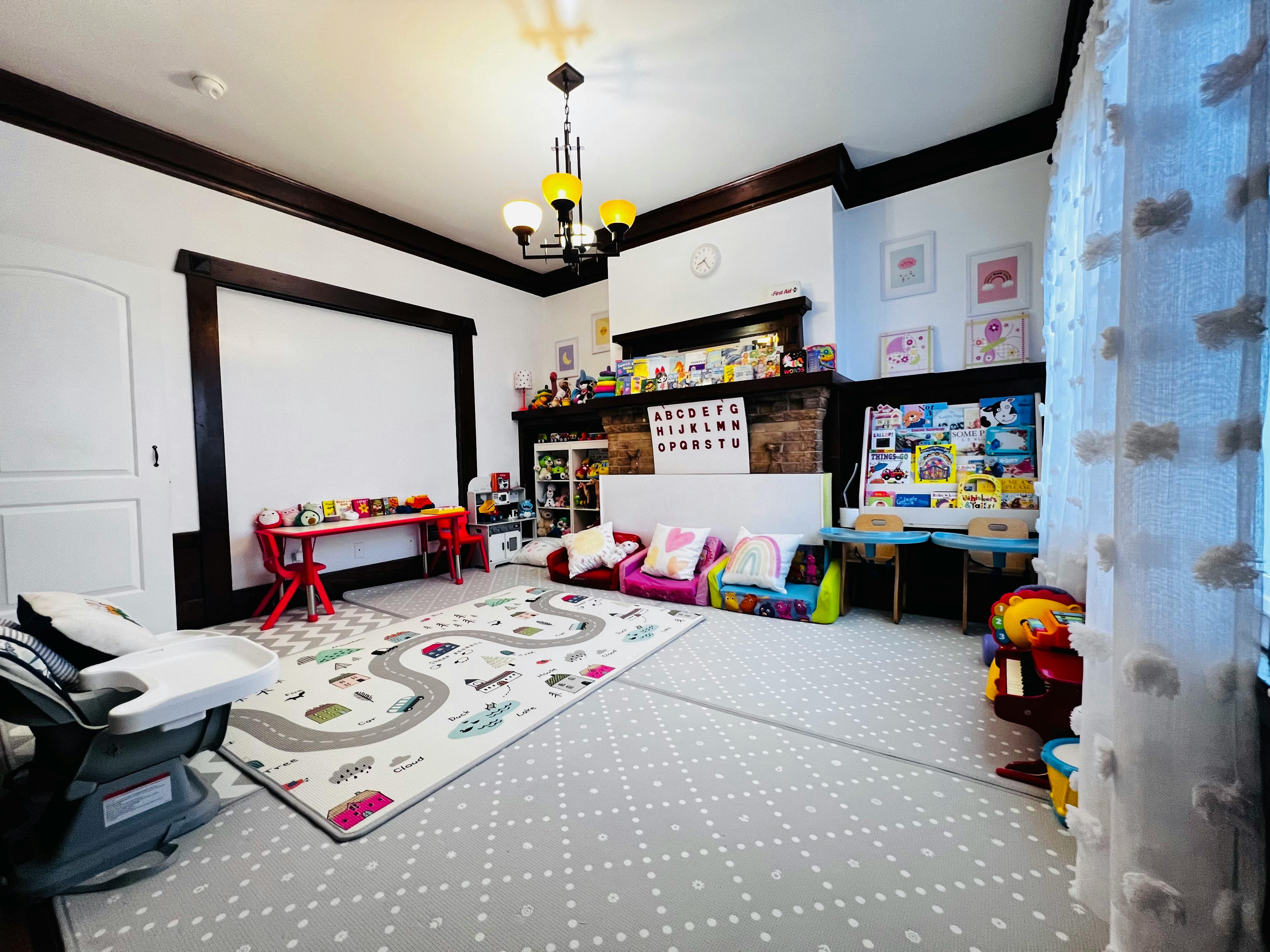 Playroom with a road map rug, small tables, and colorful cushions