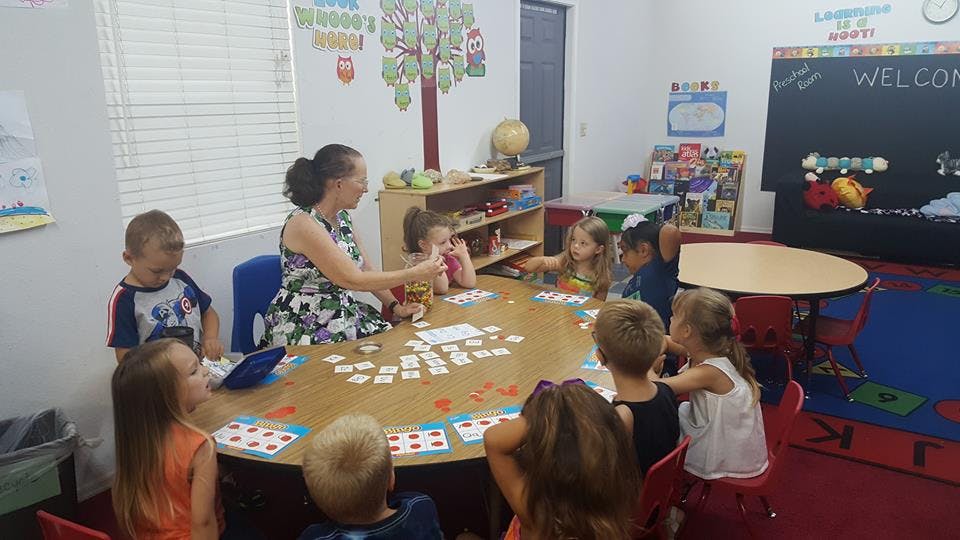 Adult and children sitting around a table in a classroom