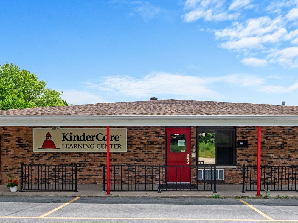 Brick building with a "KinderCare Learning Center" sign and a red door