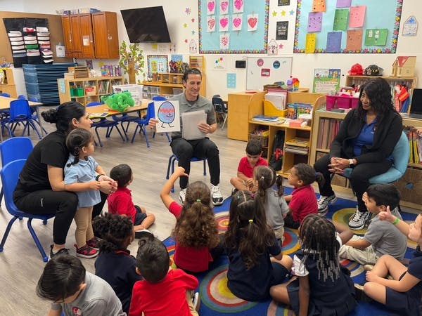 Adults reading to children in a classroom