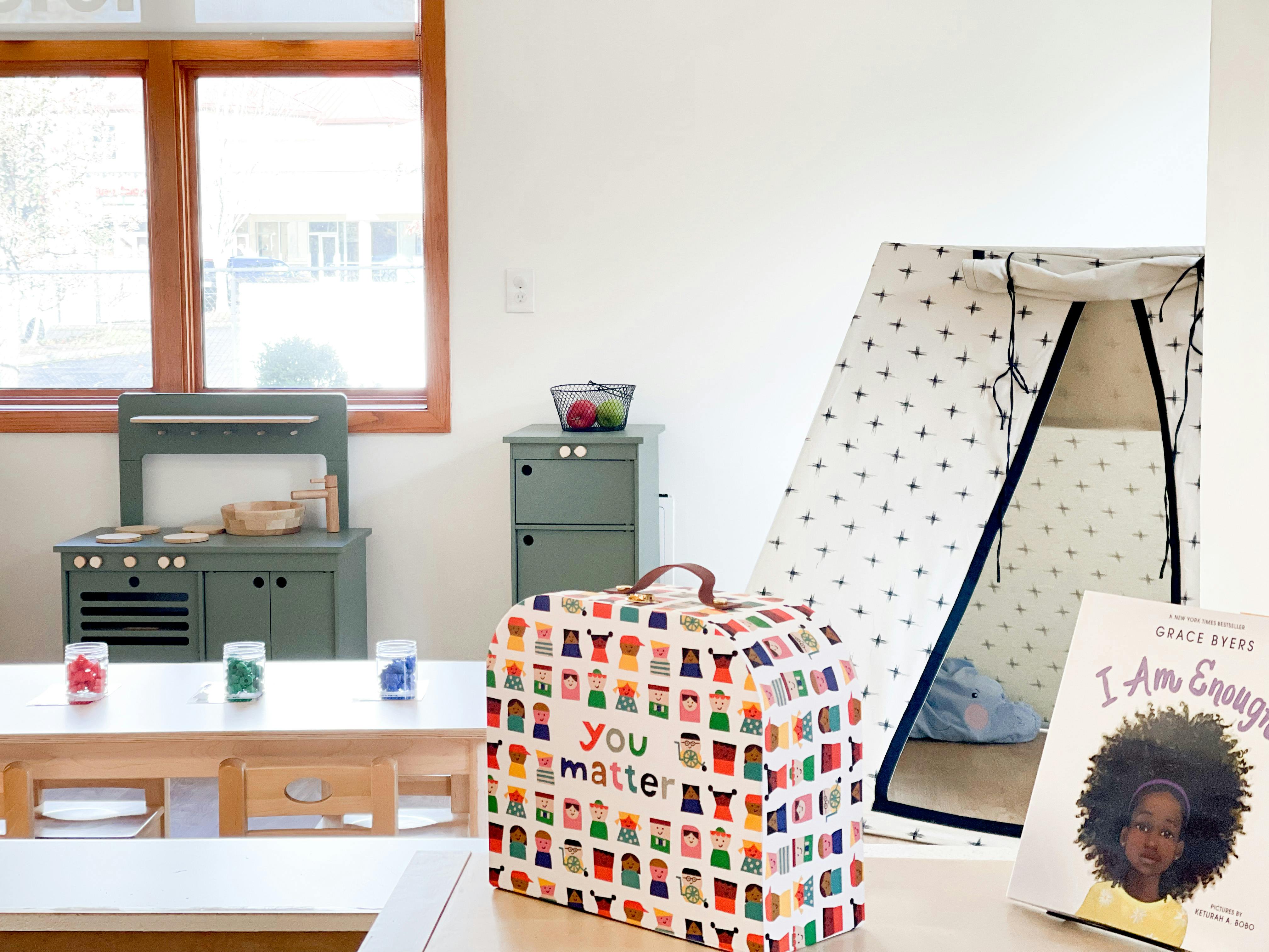 Children's play area with a toy kitchen, tent, and a box that says "you matter"