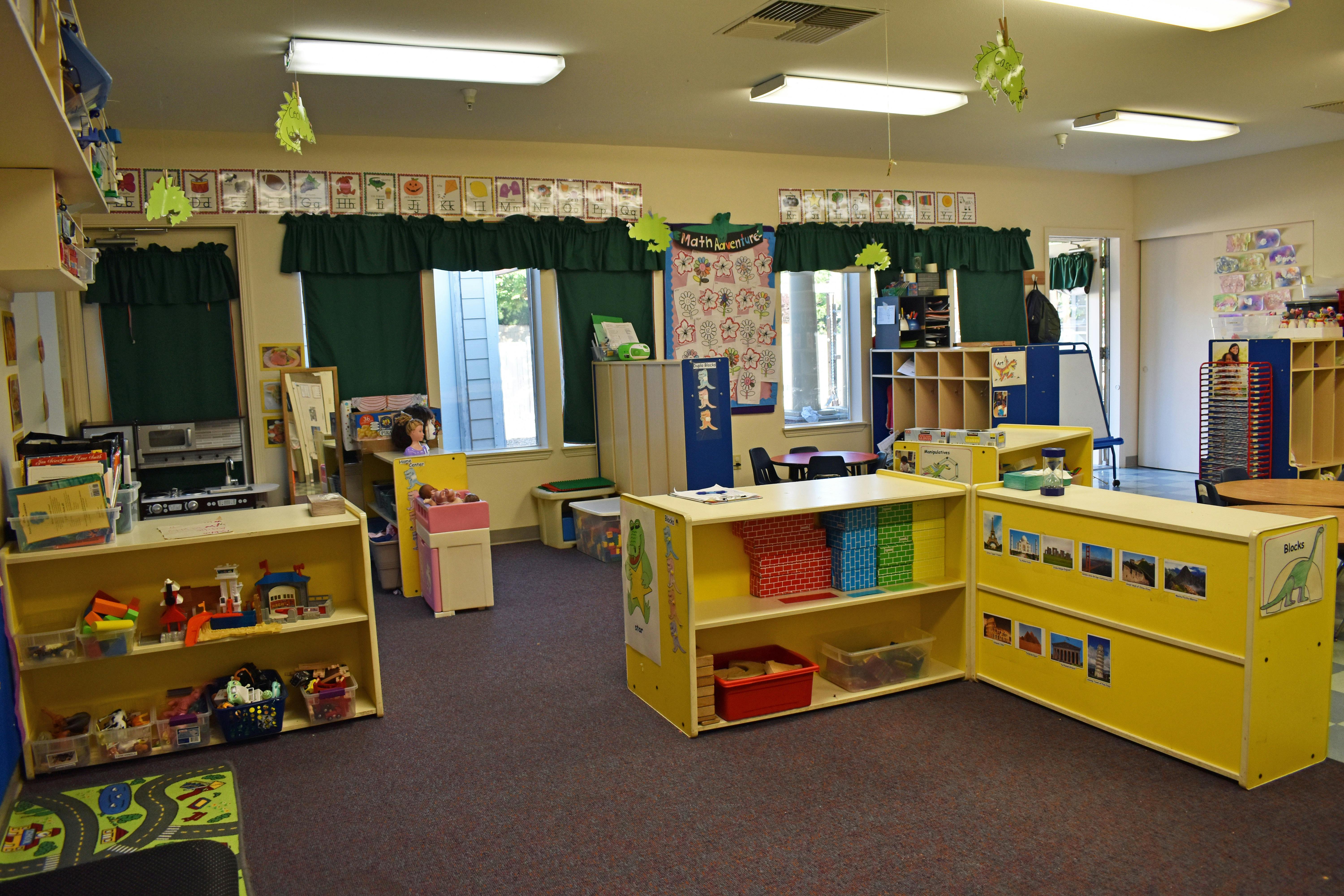 Classroom with yellow shelves and various learning materials