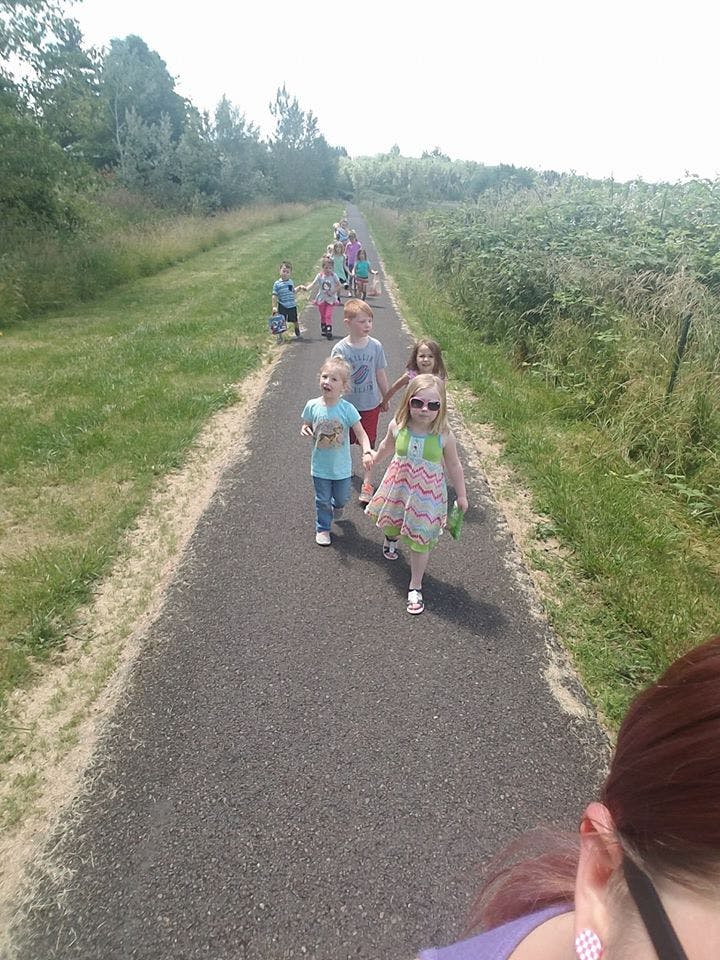 Group of children walking on a paved path outdoors