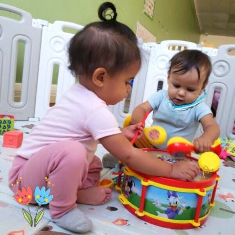 Two children playing with a toy drum