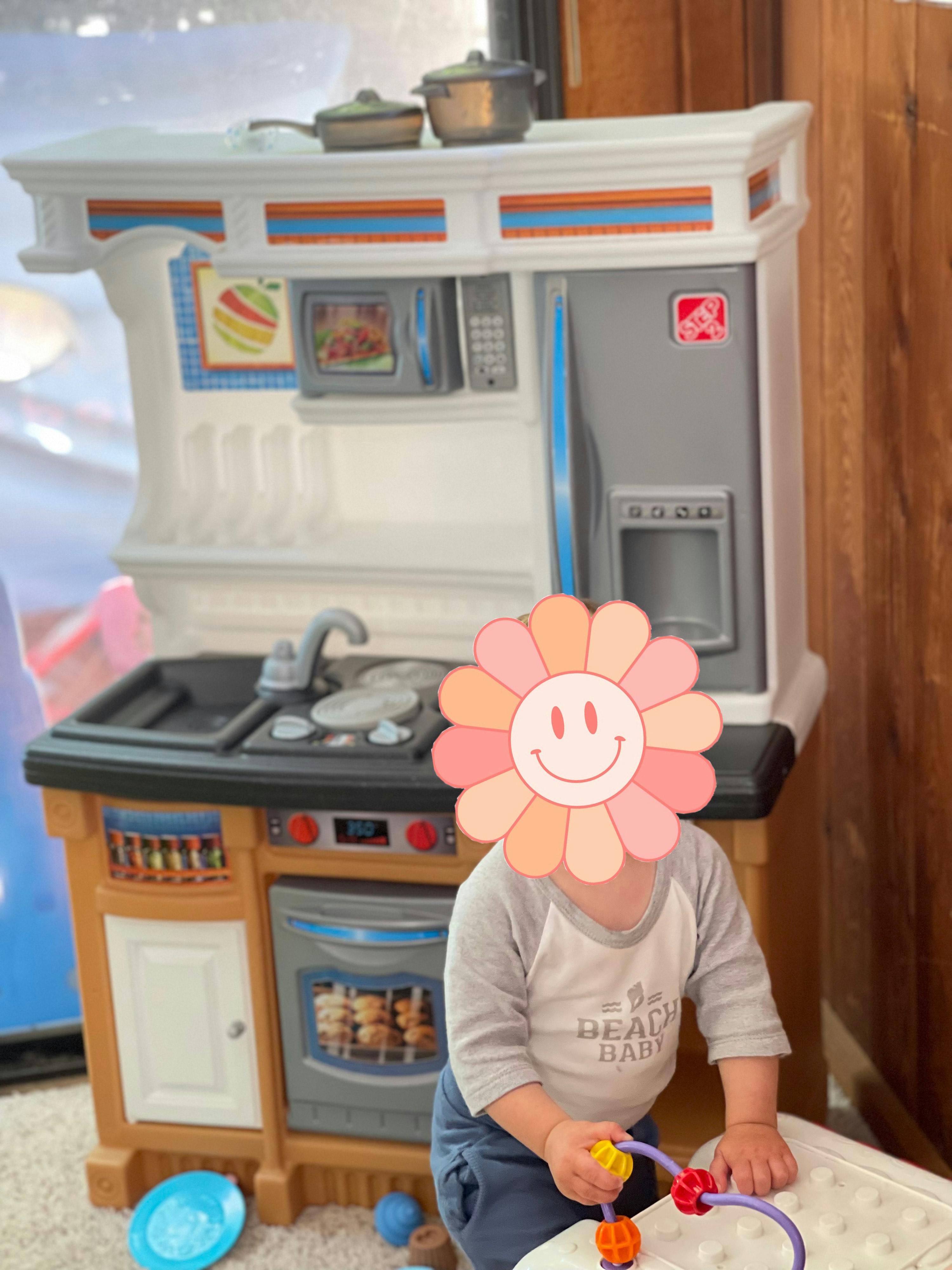 Child playing with a toy kitchen set