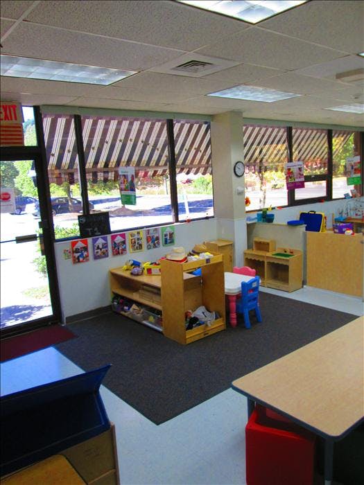 An empty classroom with small wooden shelves and tables