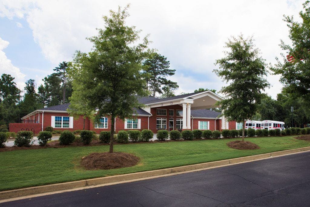 Red brick building with white columns and a green lawn