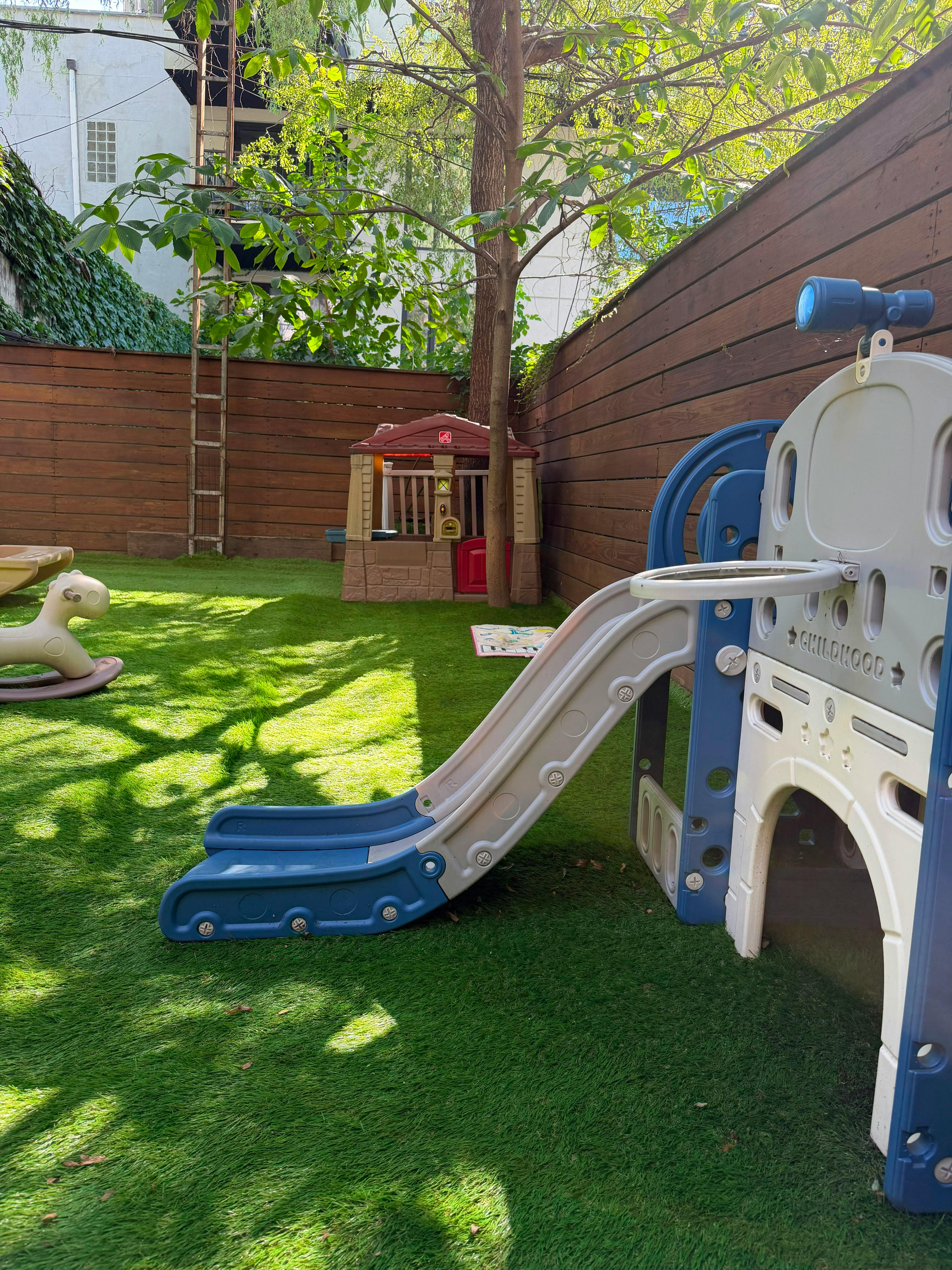 Plastic slide and play equipment on a backyard lawn