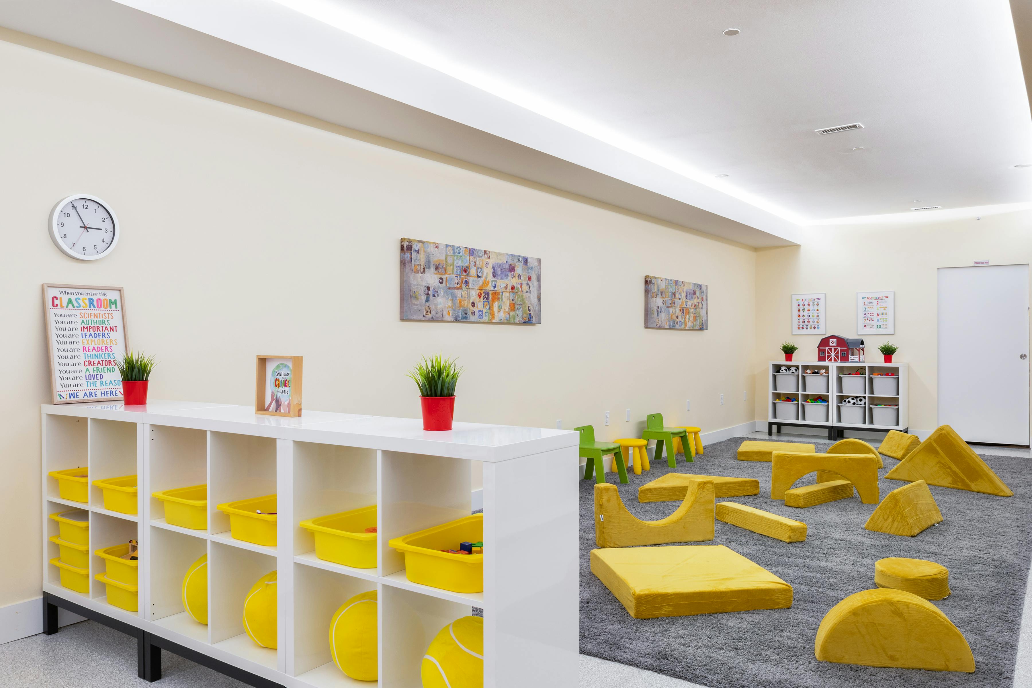 Classroom with shelves, soft play blocks, and small chairs