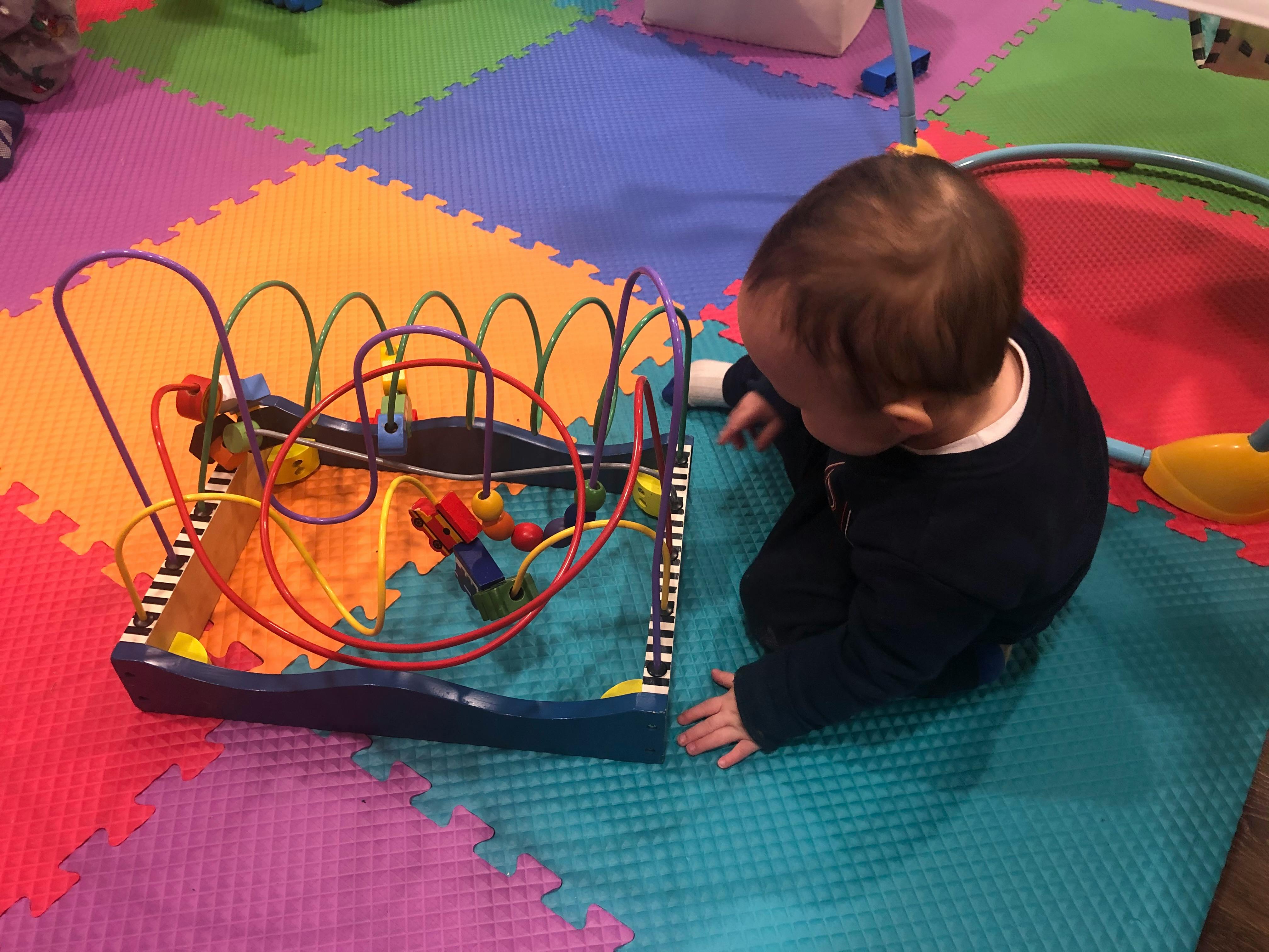 Child playing with a bead maze toy