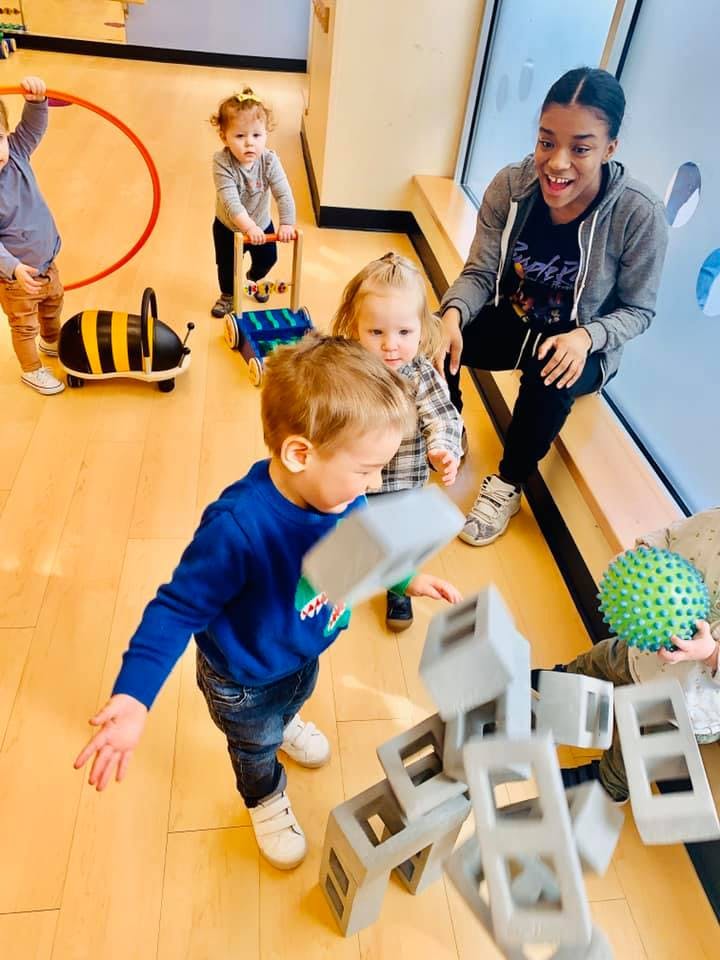 Adult and children playing with toys in a room