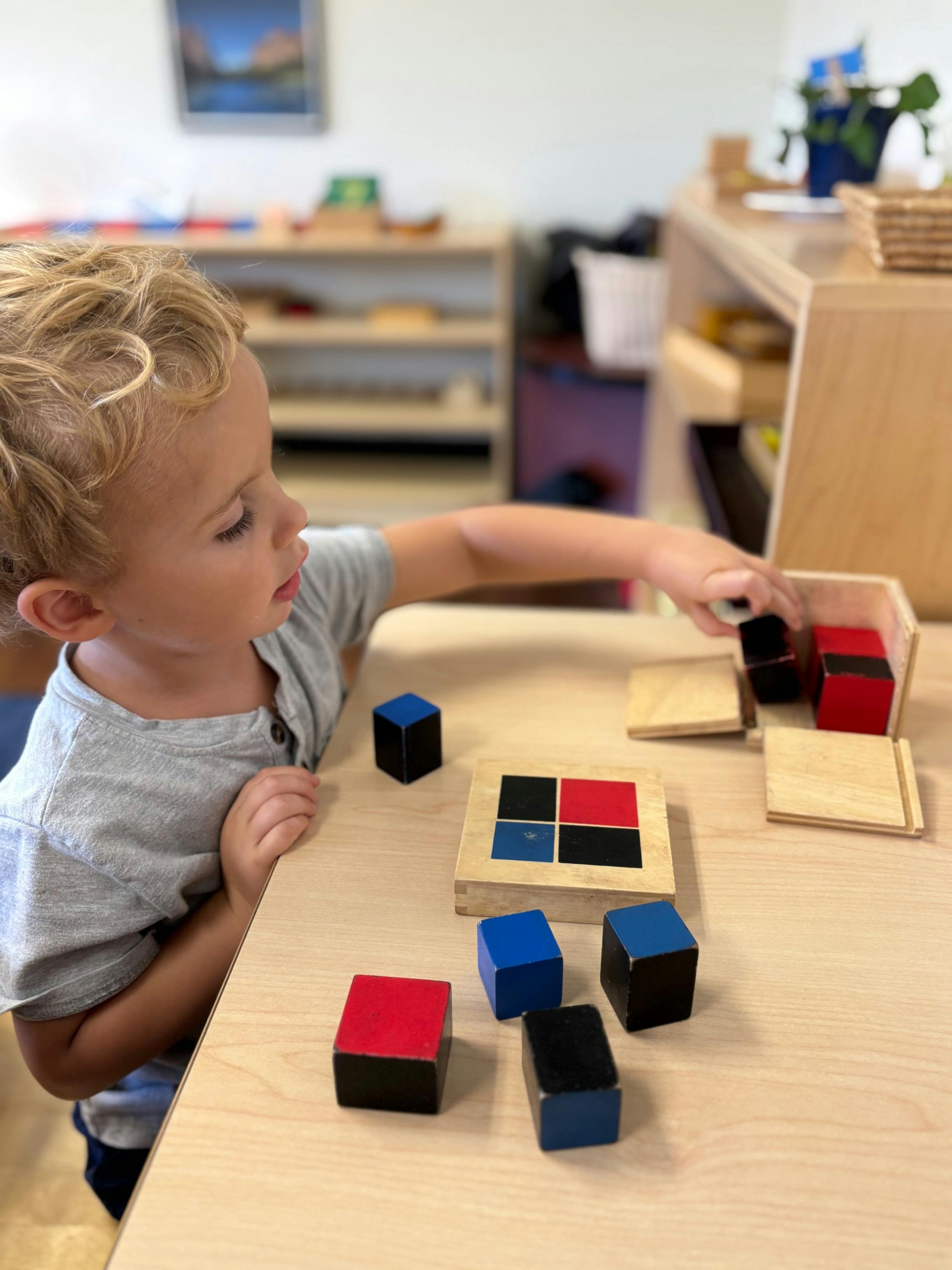 Child playing with colored wooden blocks on a table
