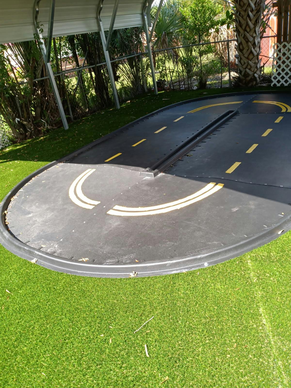 Miniature road with yellow markings on green artificial turf