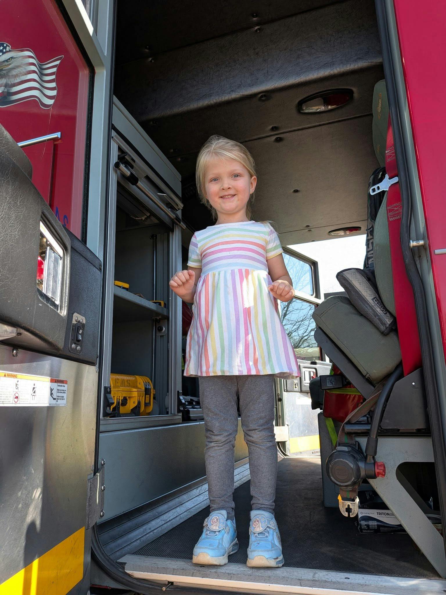 Child standing in the doorway of a fire truck