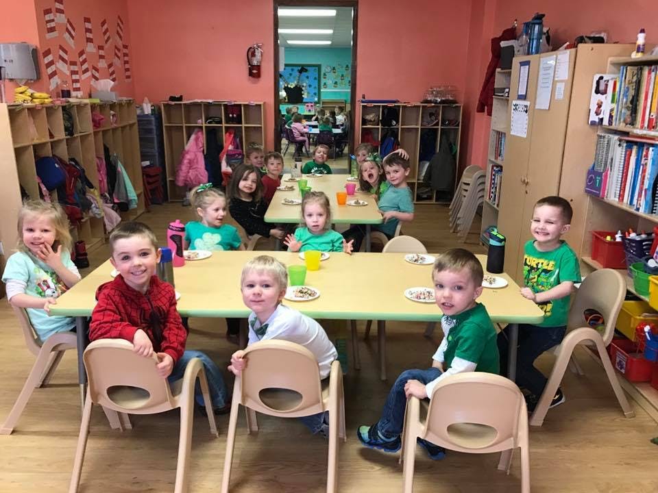 Children sitting at tables in a classroom