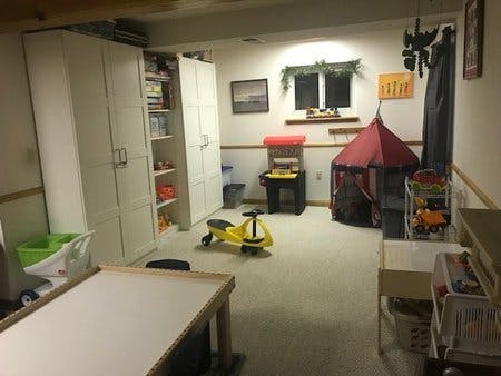 Playroom with a yellow ride-on toy and a red play tent