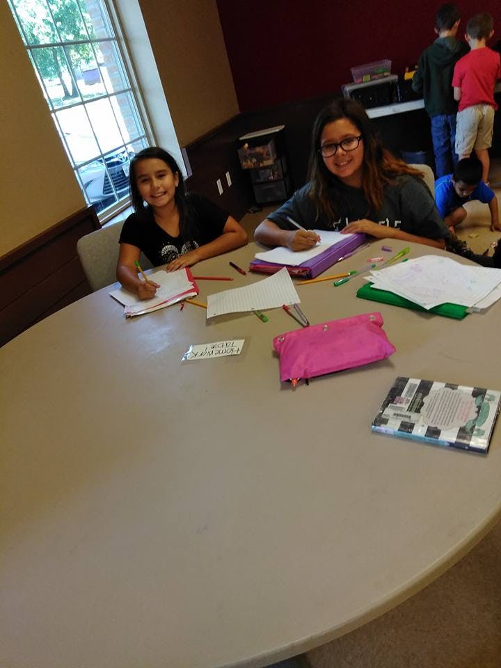 Two children writing at a table