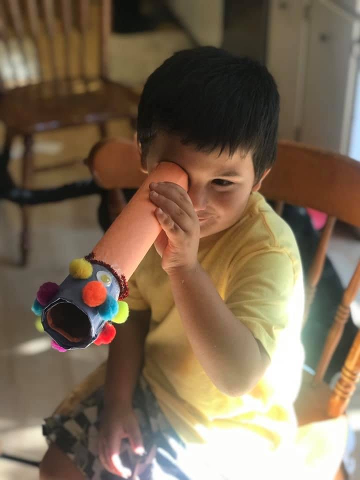 Child looking through a toy kaleidoscope