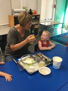 Adult and child at a table with mixing bowls and ingredients