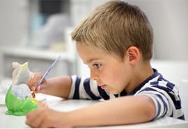 Child painting a small ceramic figure