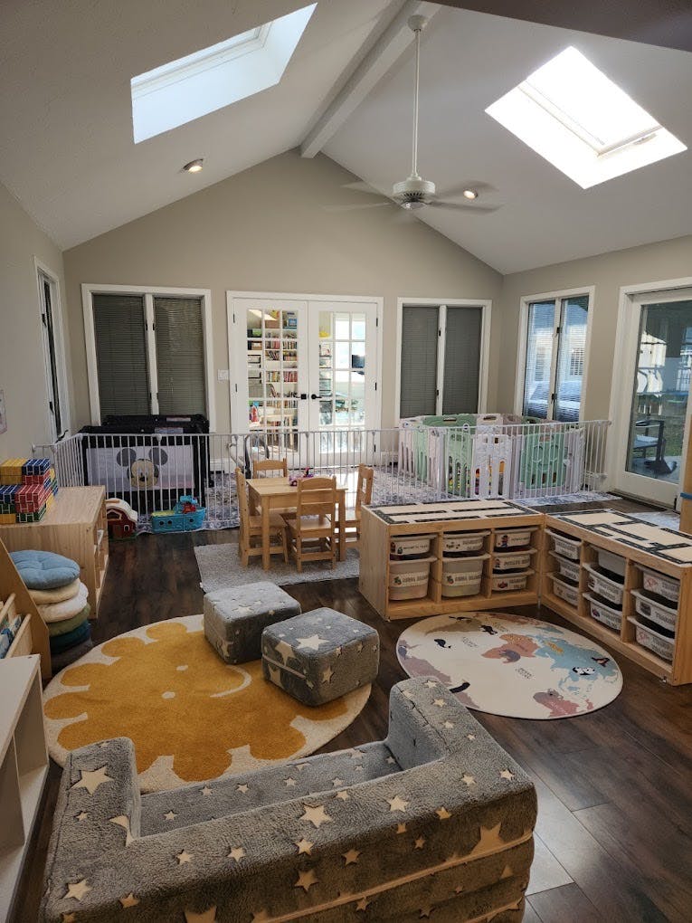 Playroom with small tables, seating, rugs, and storage for toys