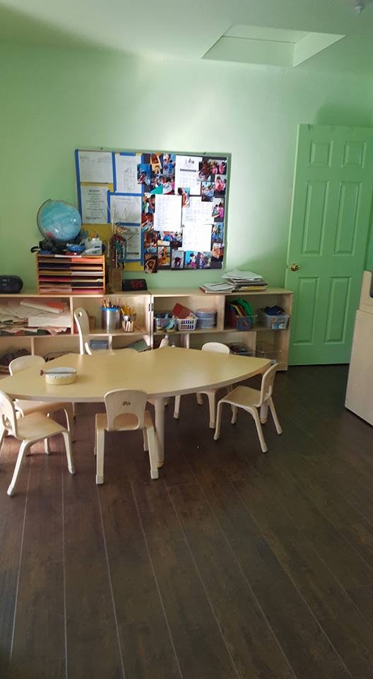 Classroom with a small table and chairs, shelves, and a bulletin board