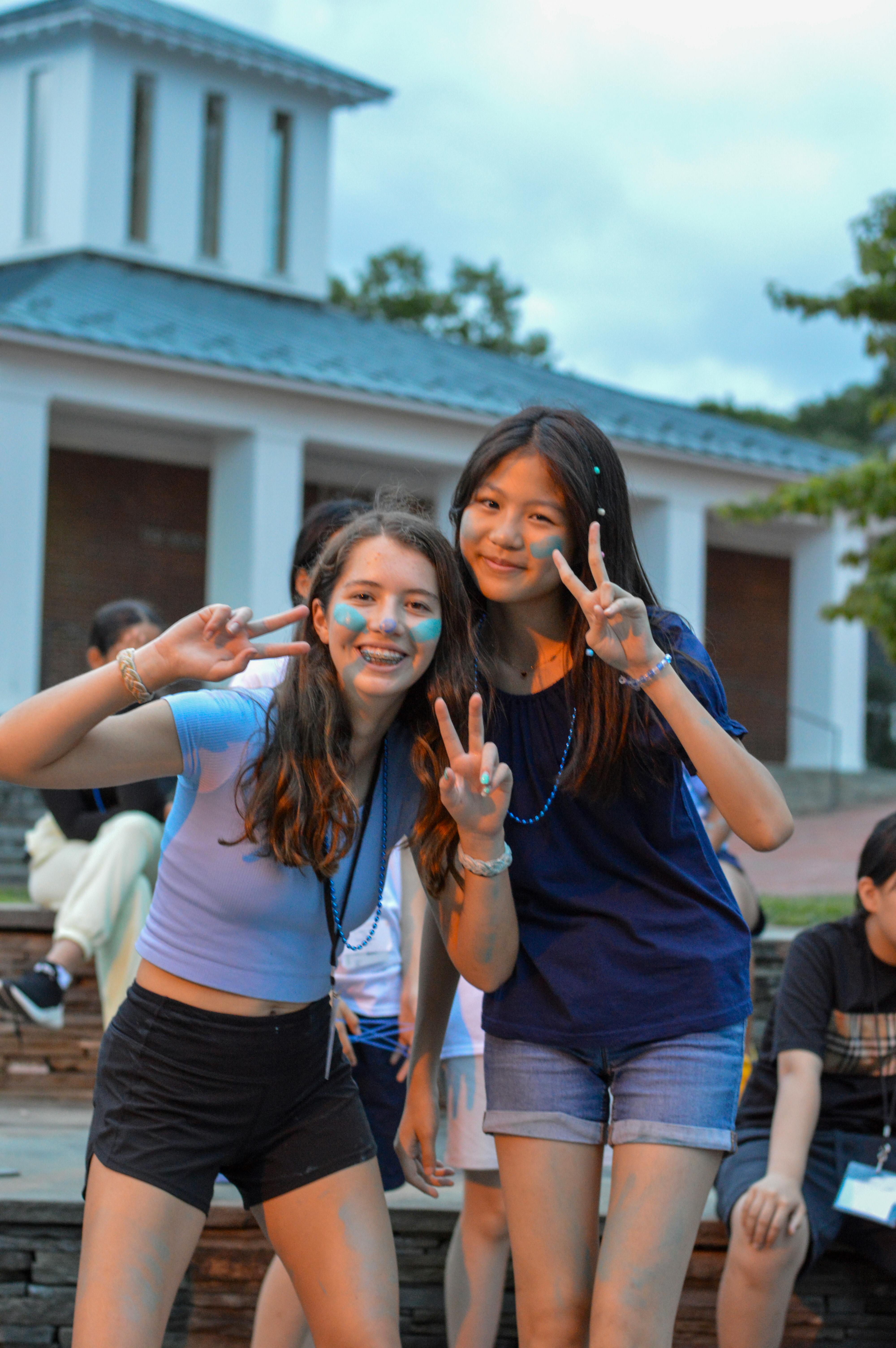 Two teens making peace signs with their hands