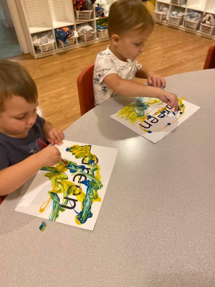 Two children painting at a table