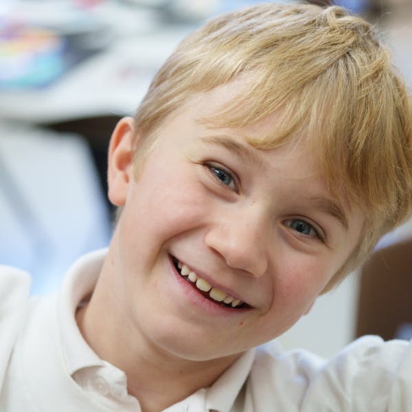 Close-up of a smiling child with blonde hair
