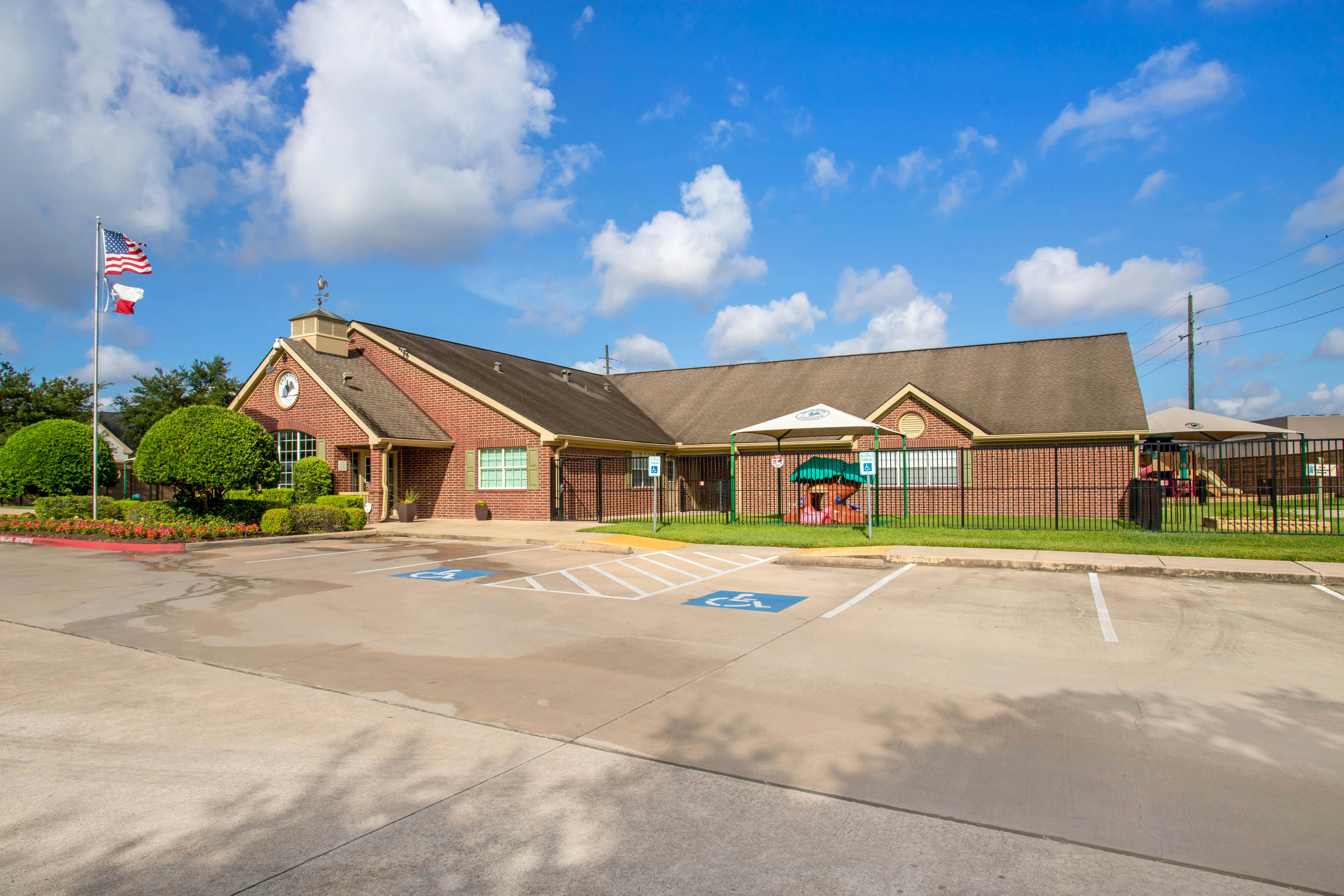 Brick building with a parking lot and a fenced playground