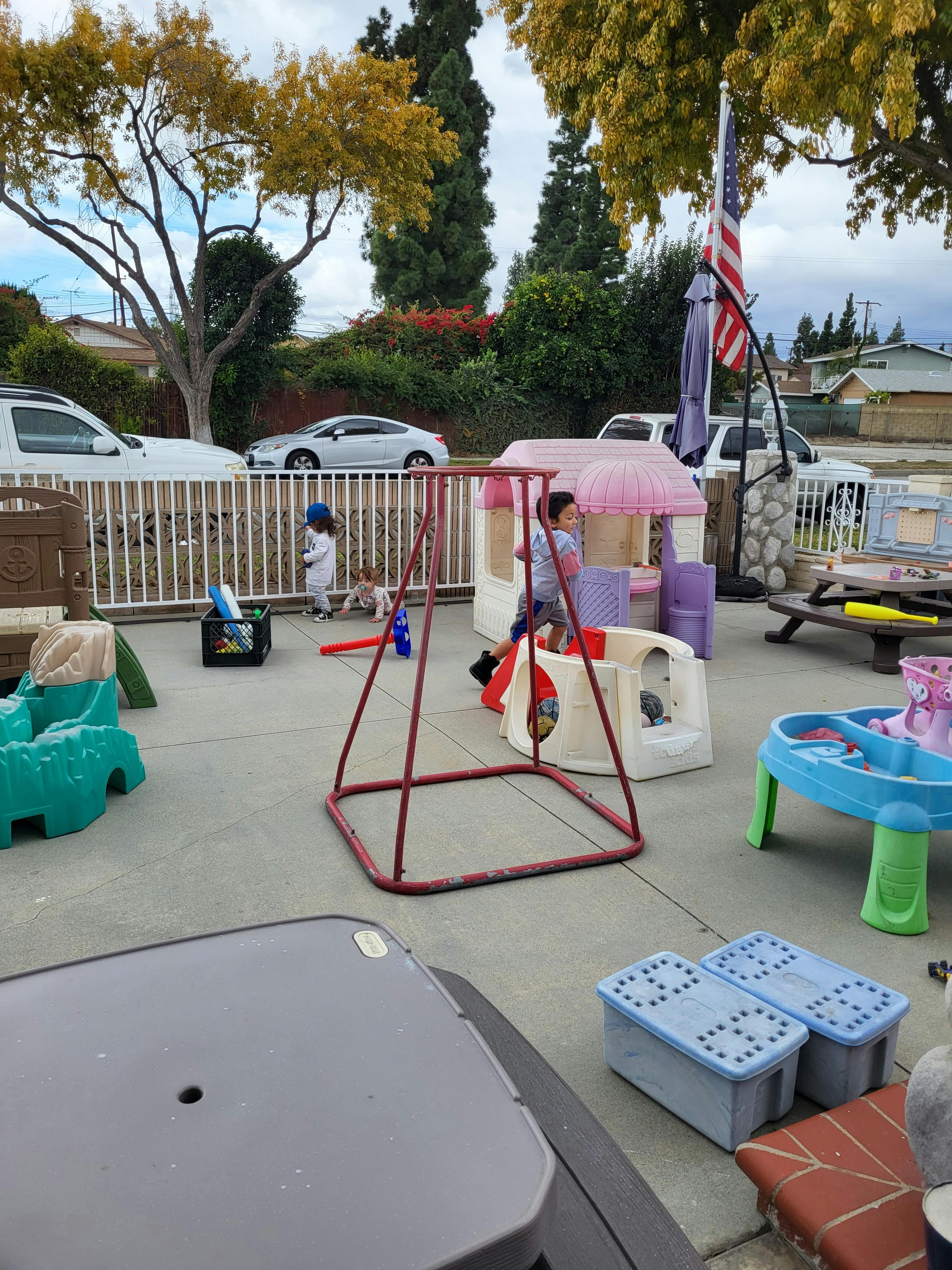 Child playing in a toy house on a patio