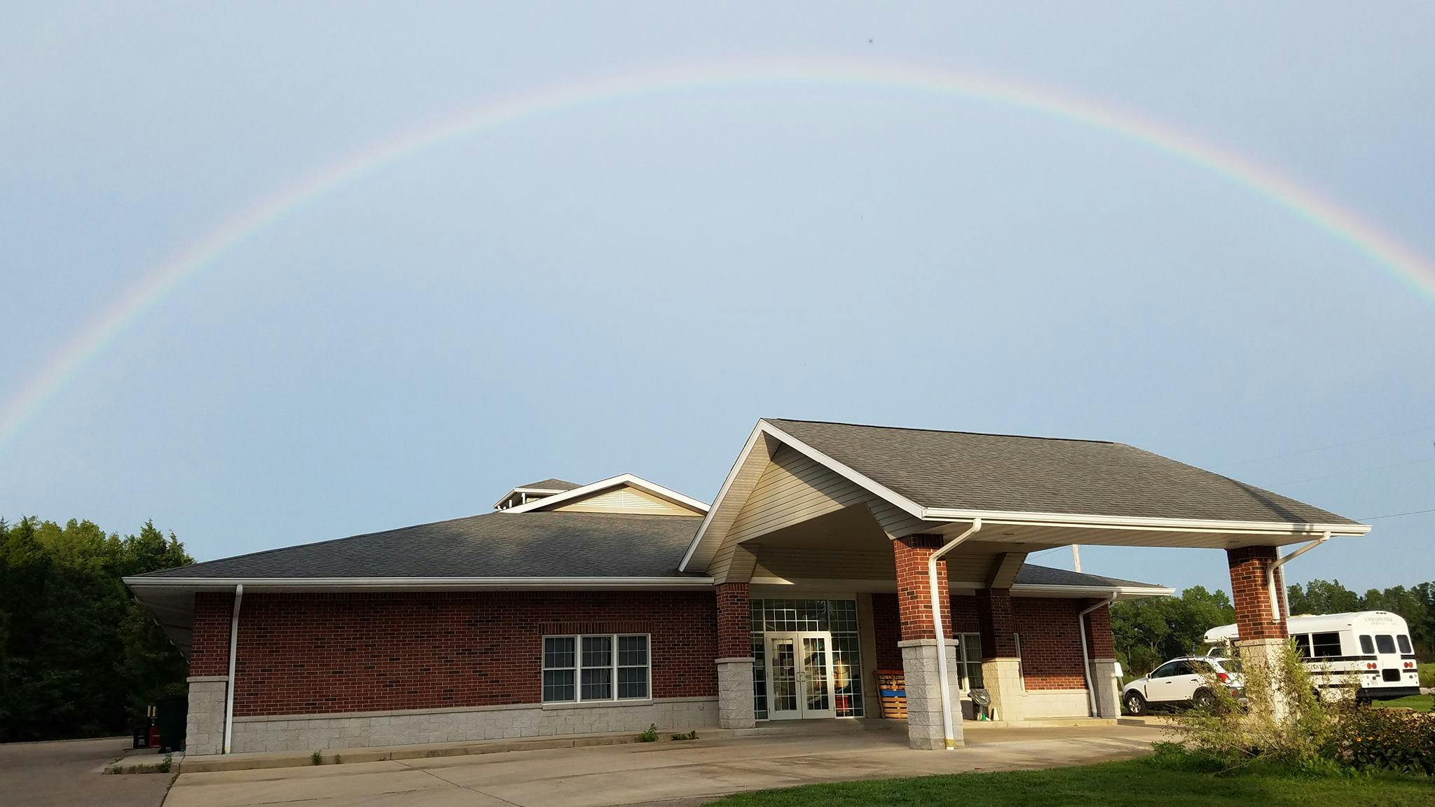 Building with a covered entrance under a rainbow