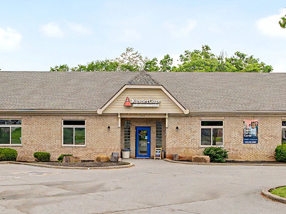 Brick building with a dark roof and a KinderCare sign above the entrance