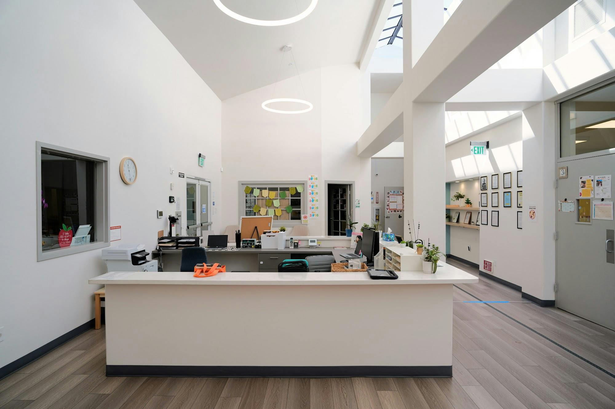 Reception desk in a bright, modern building lobby with vaulted ceilings