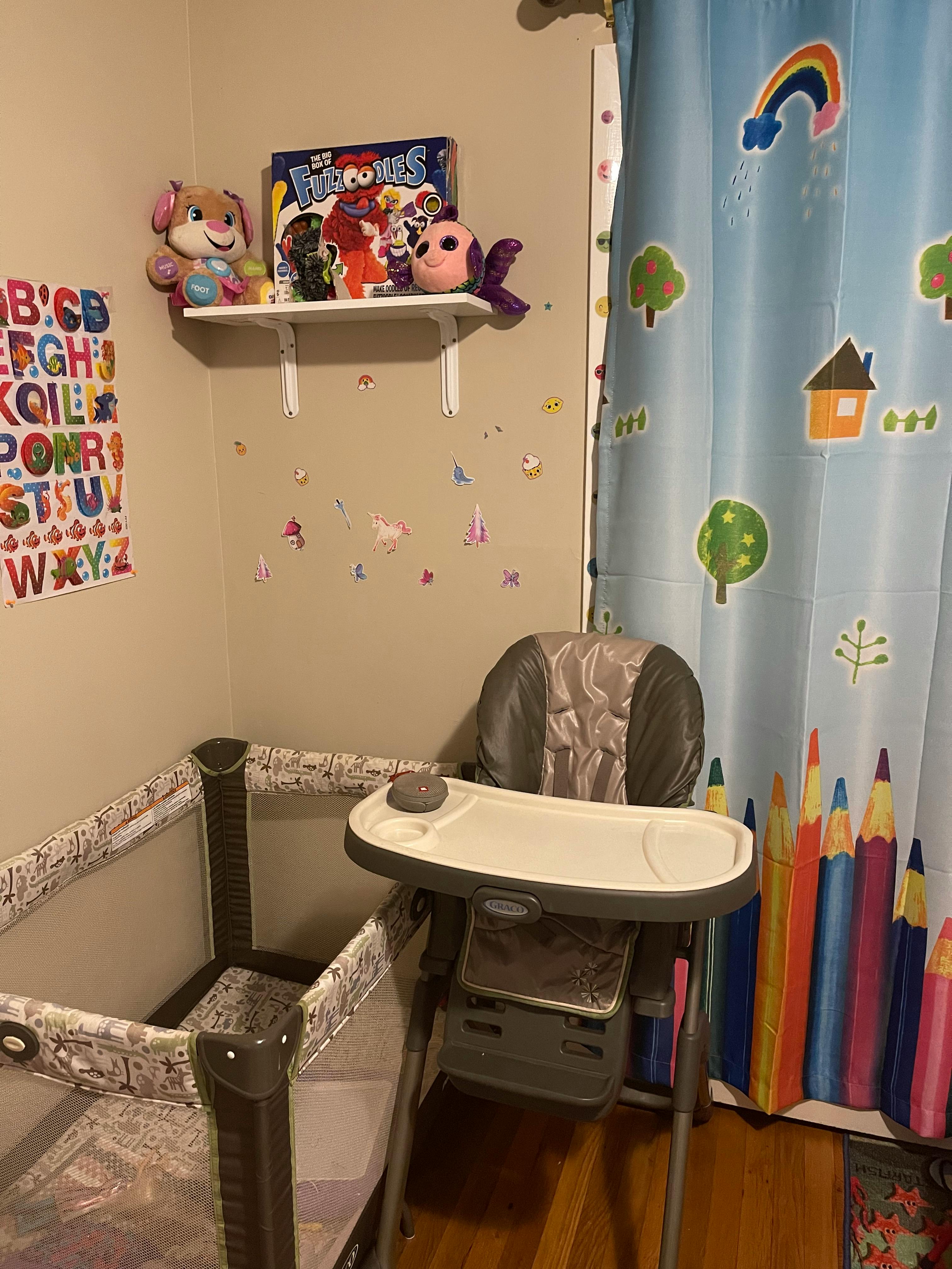 High chair next to a playpen in a child's room