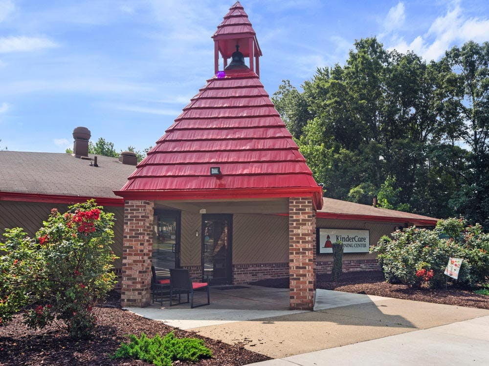 Entrance to a KinderCare Learning Center building with a red bell tower