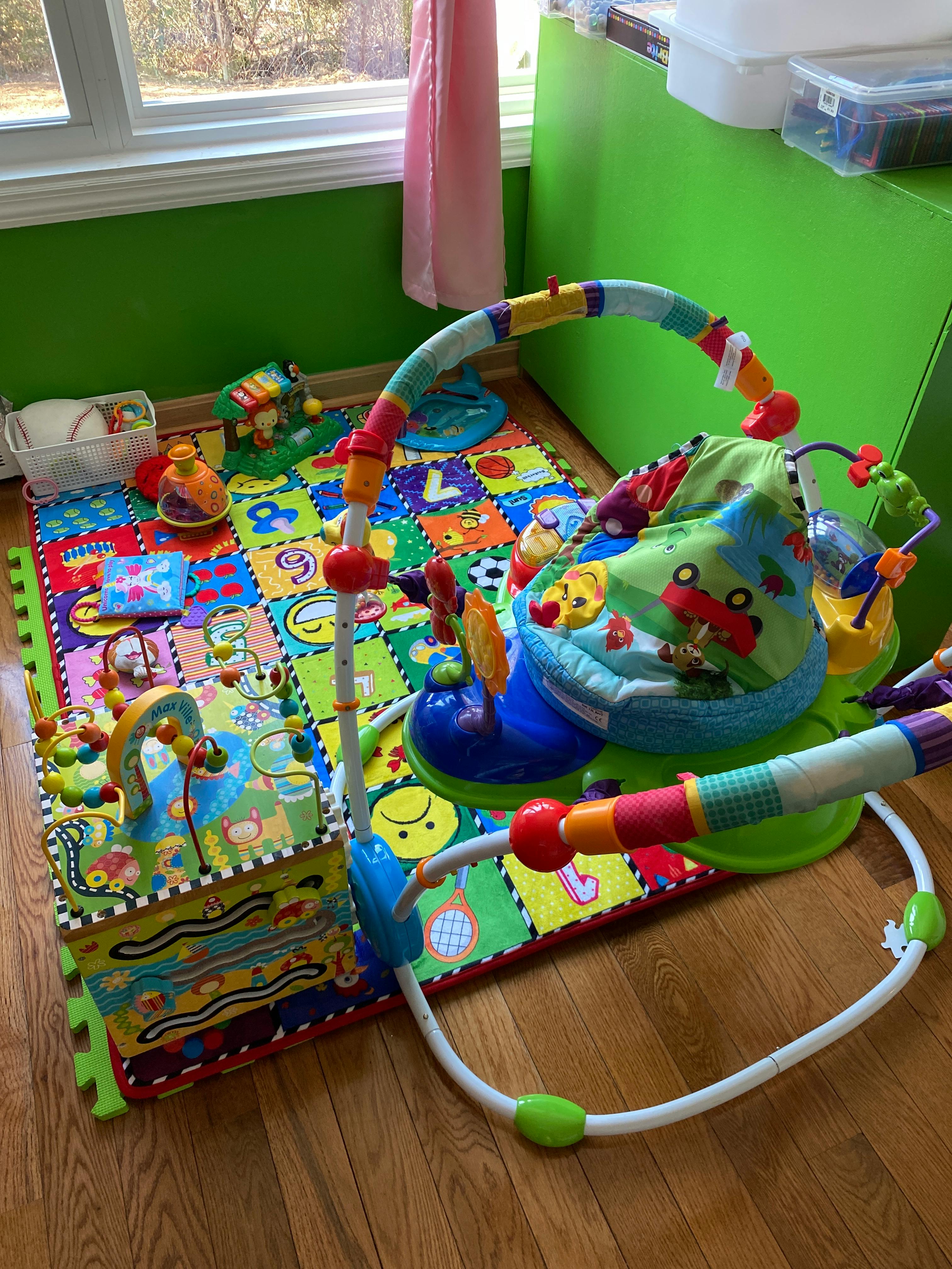 Baby play mat with various toys and an activity center