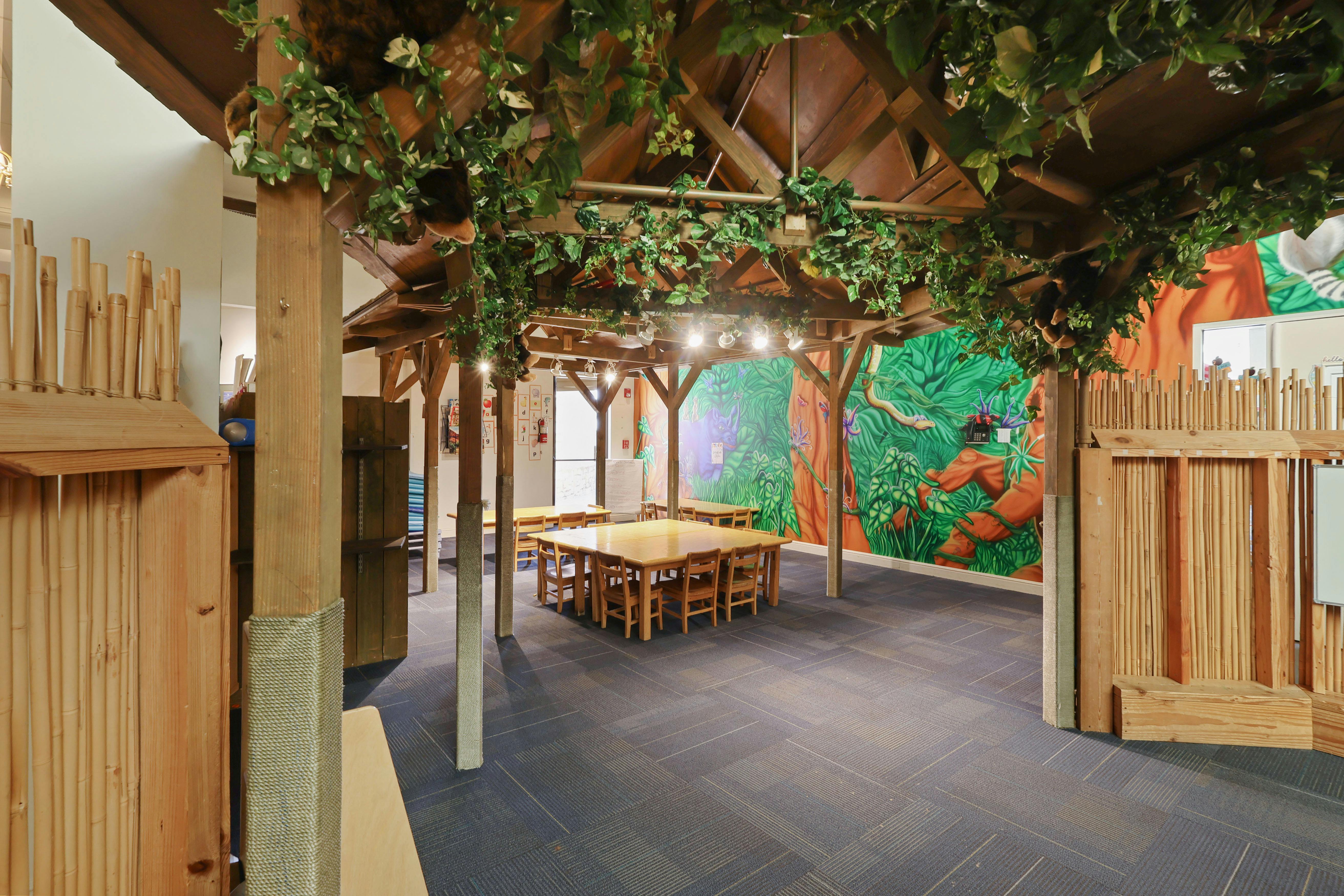 Classroom with jungle theme decorations including mural and hanging vines