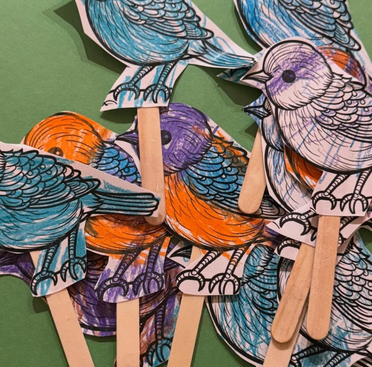 Bird puppets made from paper cutouts and craft sticks