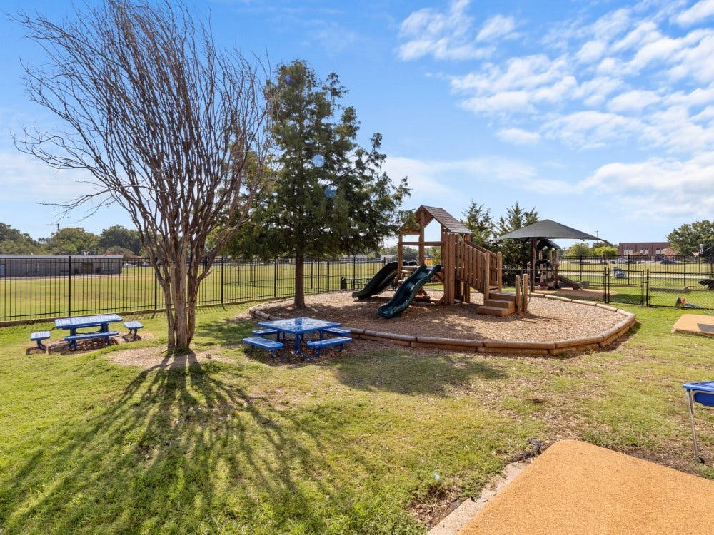 Outdoor playground with slides, picnic tables, and a climbing structure