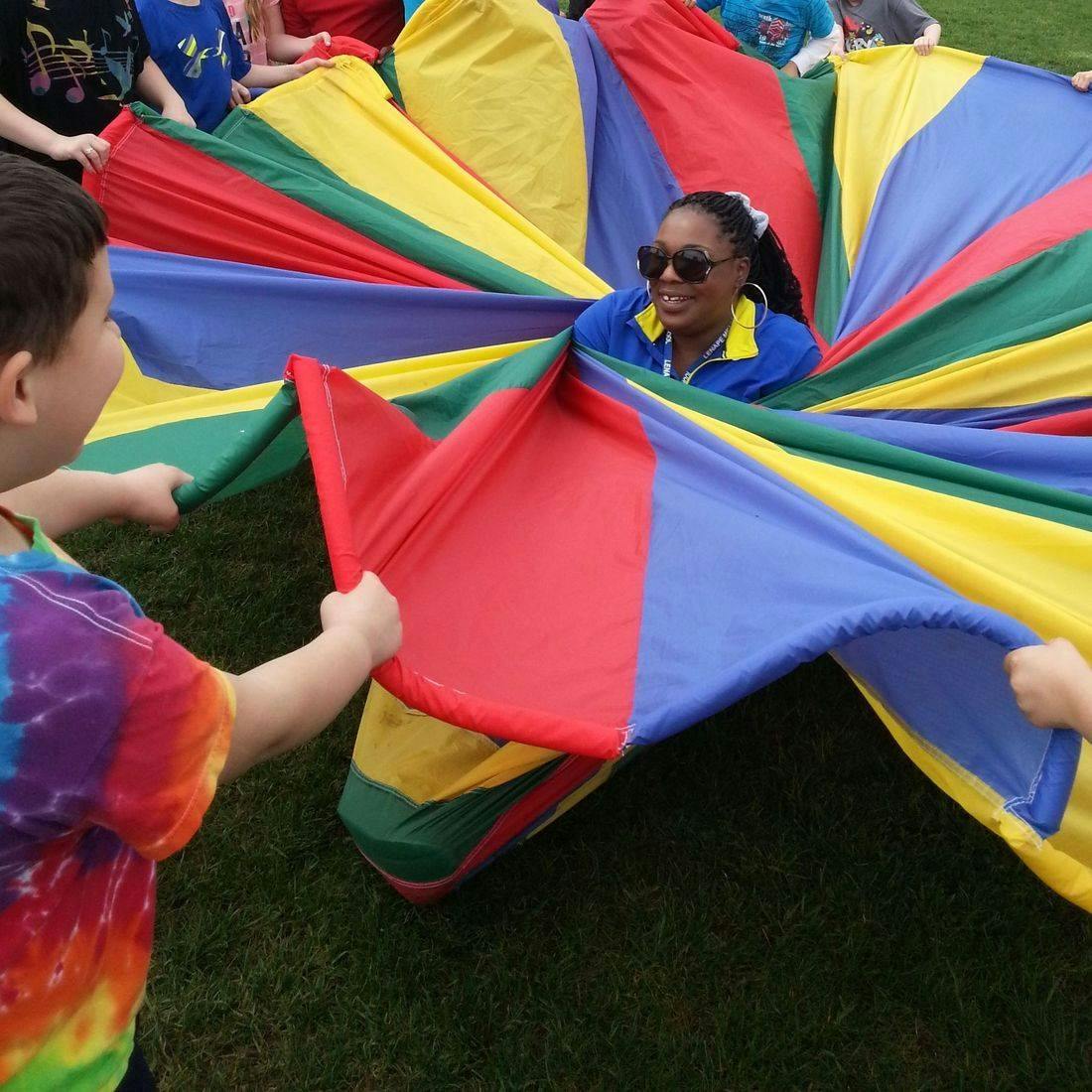 Person and child holding a colorful parachute