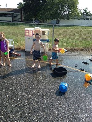 Children playing with water and toys outdoors