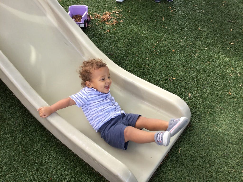 Child sliding down a playground slide