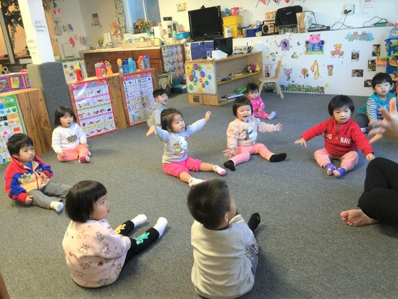 Multiple children sitting on the floor in a classroom