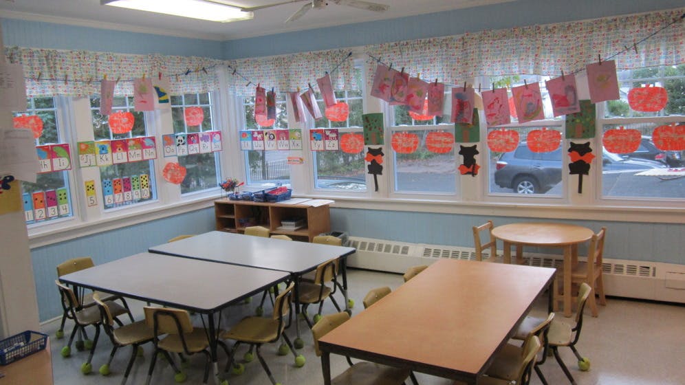 Classroom with tables, chairs, and decorated windows