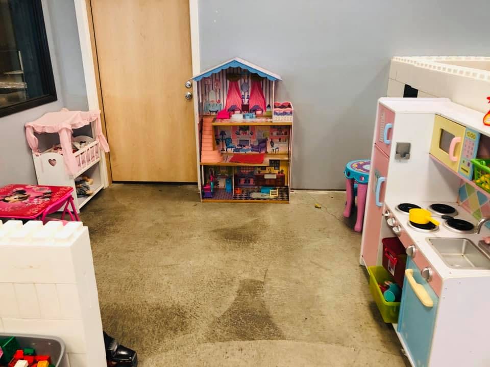 Dollhouse and toy kitchen in a room